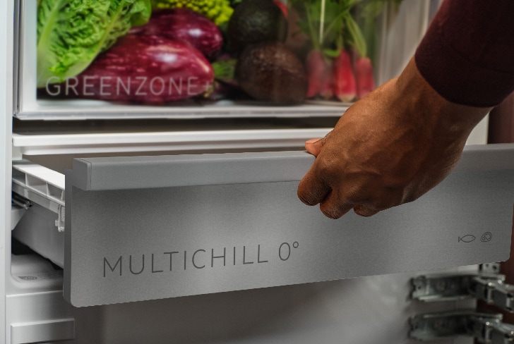 Muž vytahující zásuvku MultiChill uvnitř chladničky.